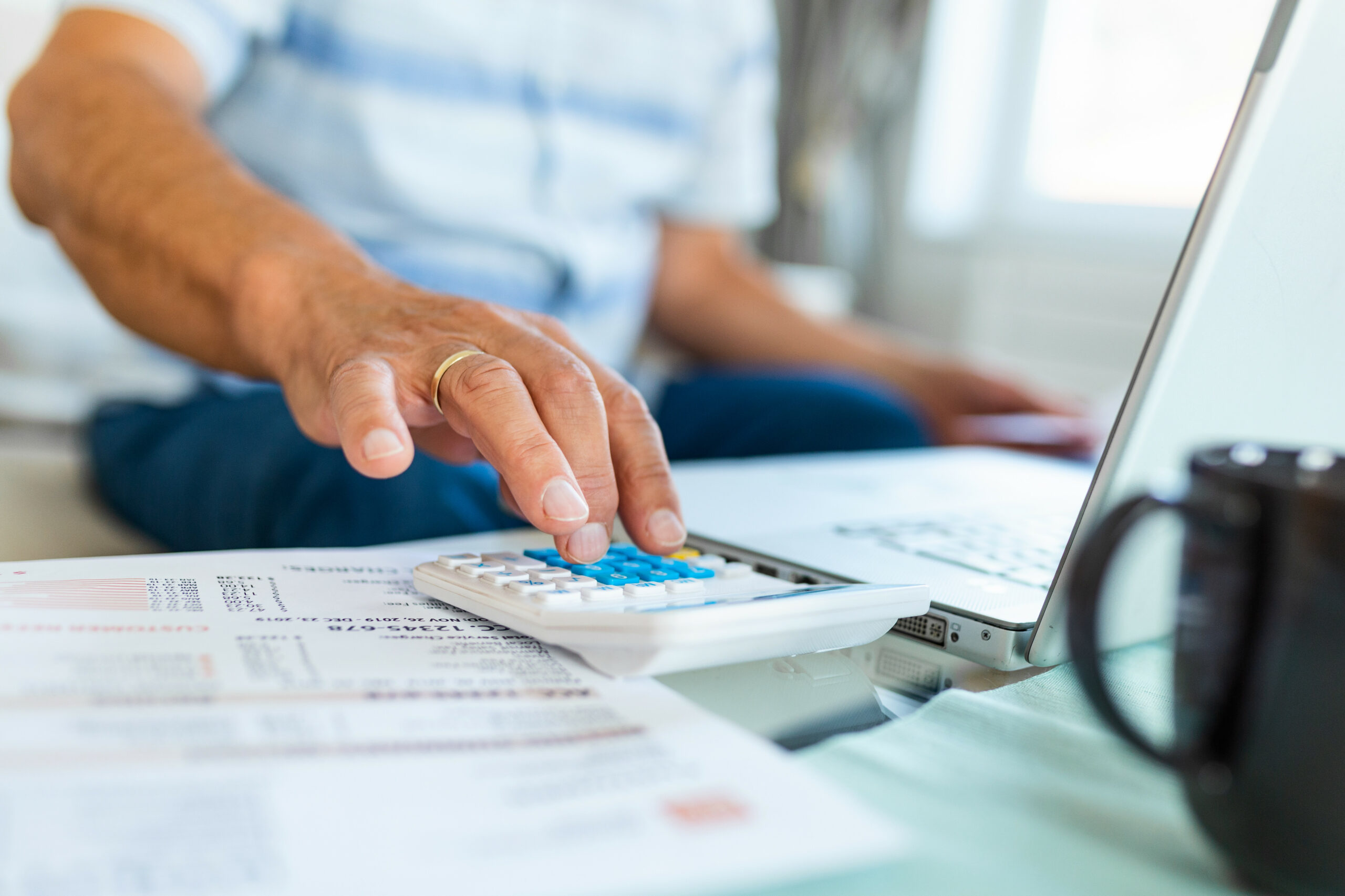 Serious elder senior grey haired grandpa using calculator